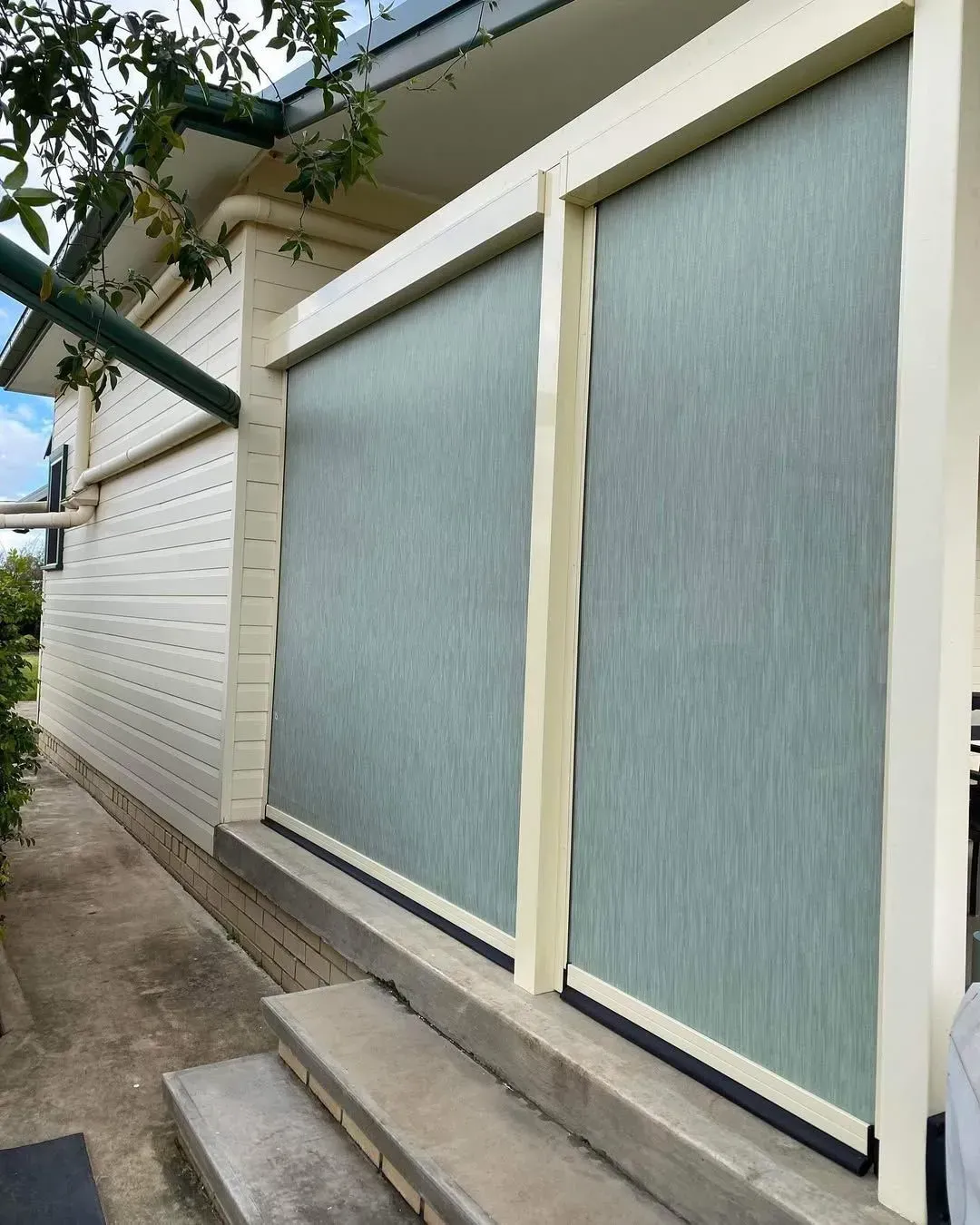 Sliding Frosted Glass Doors with Cream Trim Beside a Concrete Walkway — Tamworth Blinds & Awnings in Narrabri, NSW