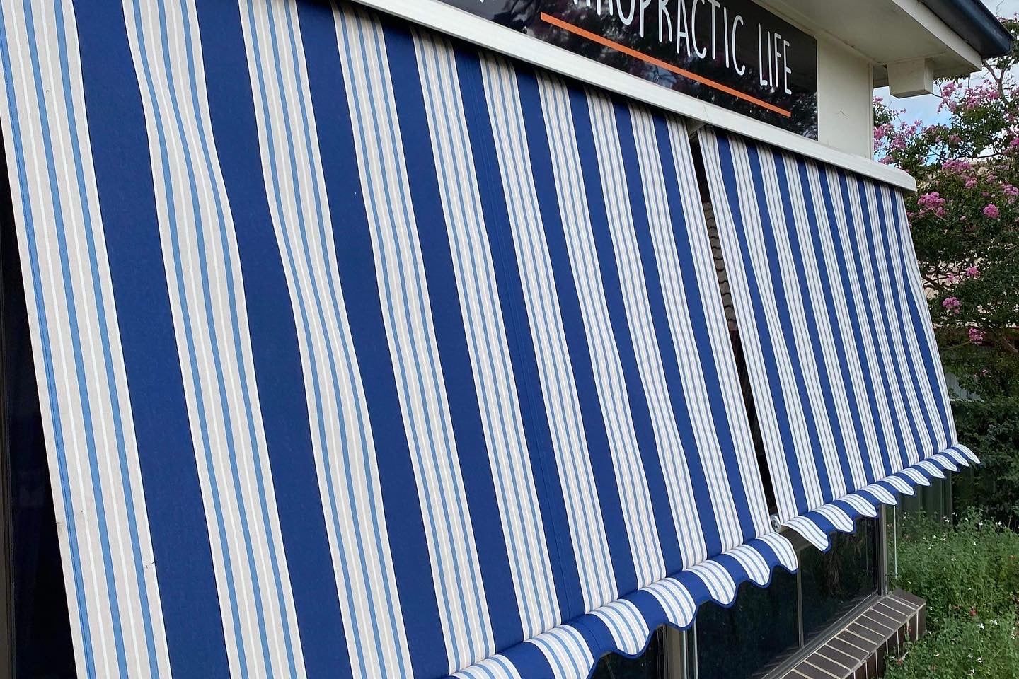 Blue-And-White Striped Awning Over a Storefront Window — Tamworth Blinds & Awnings in Tamworth, NSW