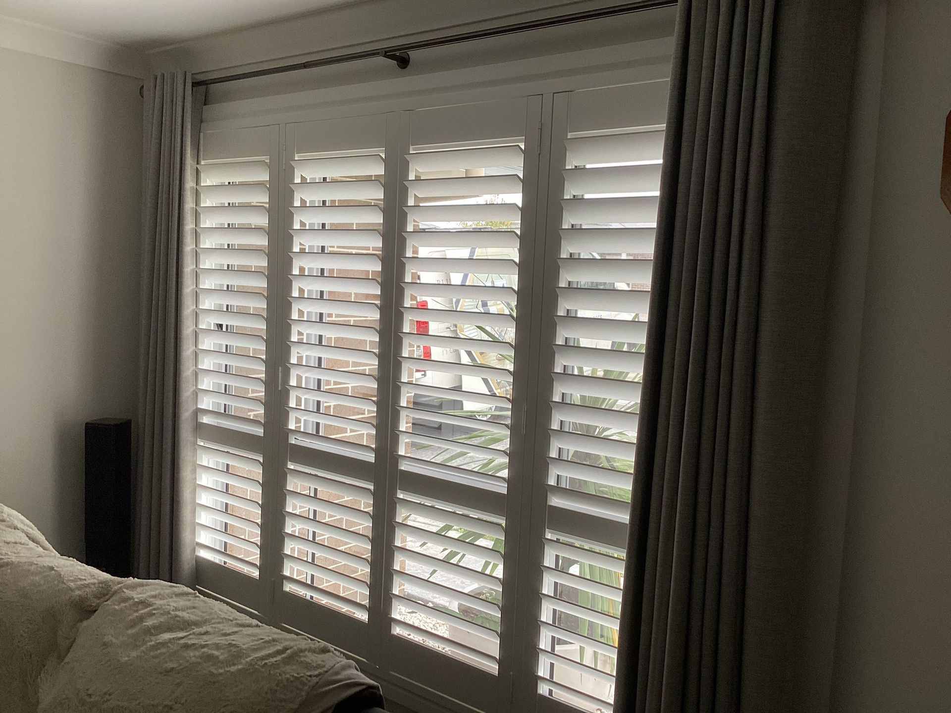 Living Room Window with White Shutters and Gray Curtains — Tamworth Blinds & Awnings in Gunnedah, NSW