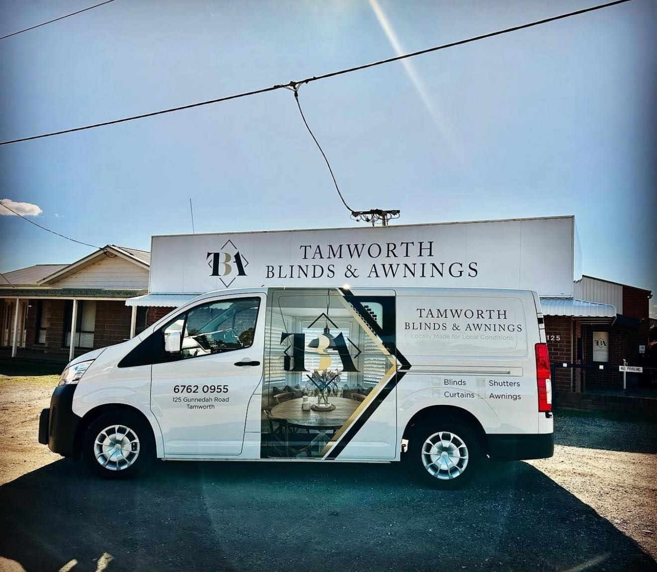 White delivery van with Tamworth Blinds & Awnings signage parked on a residential street.