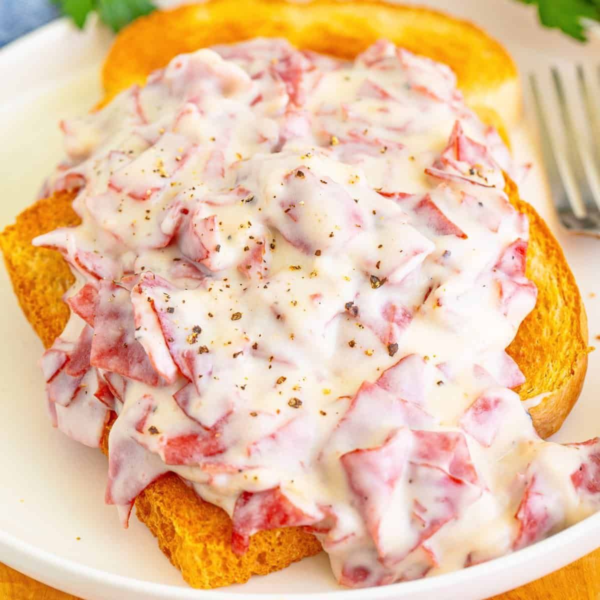 A close up of a plate of food with a fork on a table.