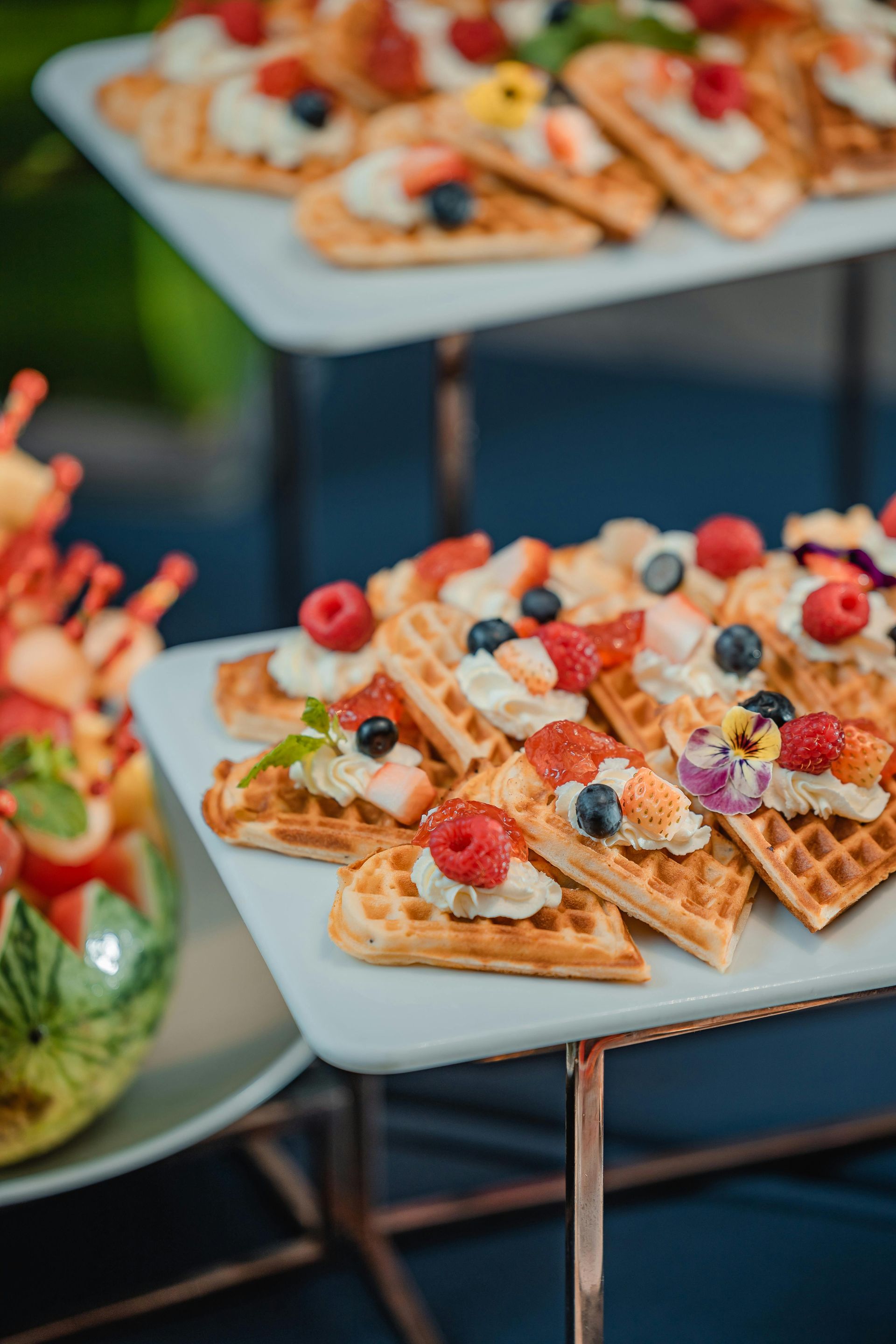 A white plate topped with waffles and fruit on a table.