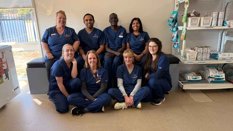 A group of nurses are posing for a picture in a room. A group of nurses are posing for a picture while sitting on the floor.