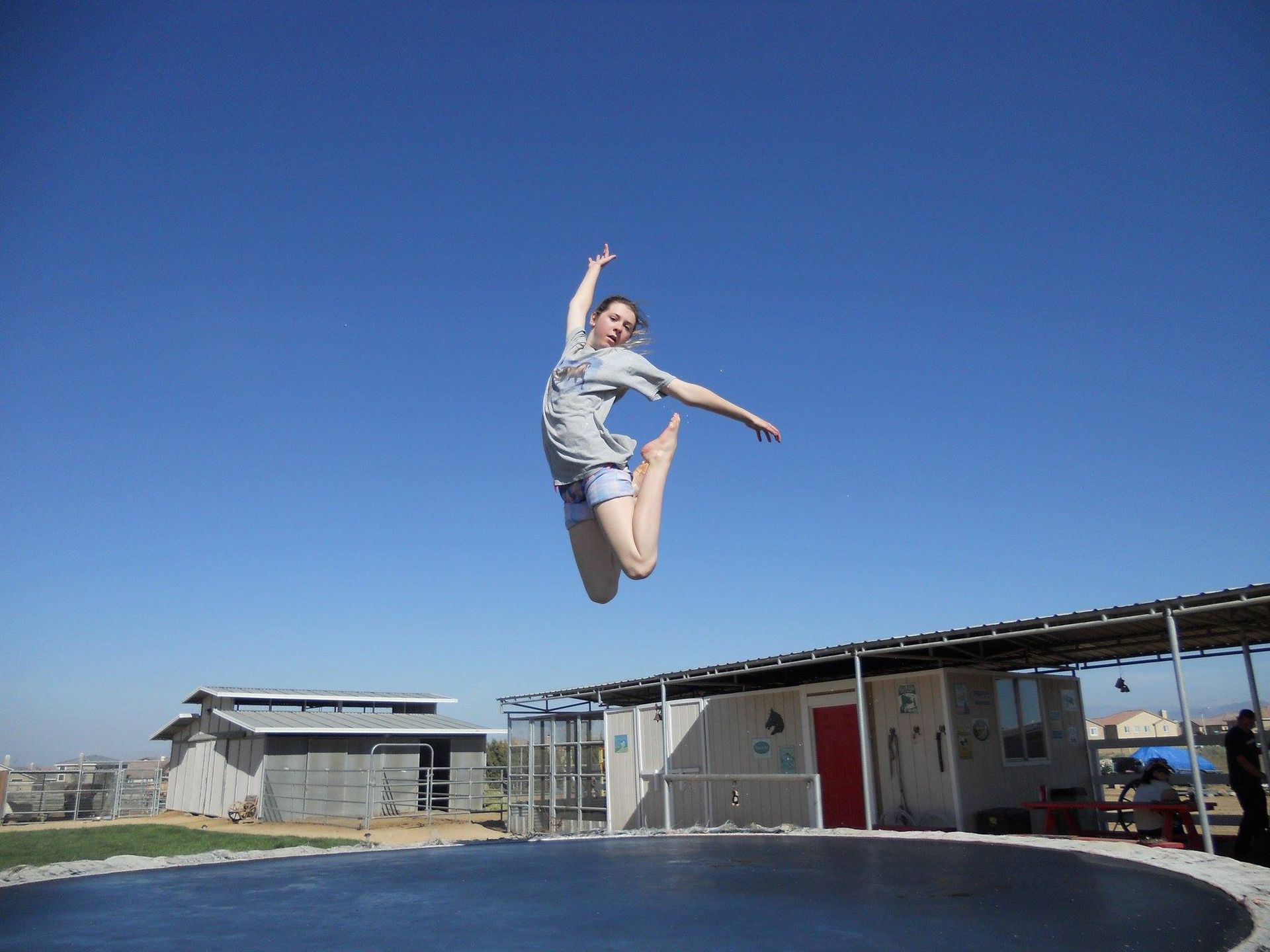 A woman is jumping in the air on a trampoline