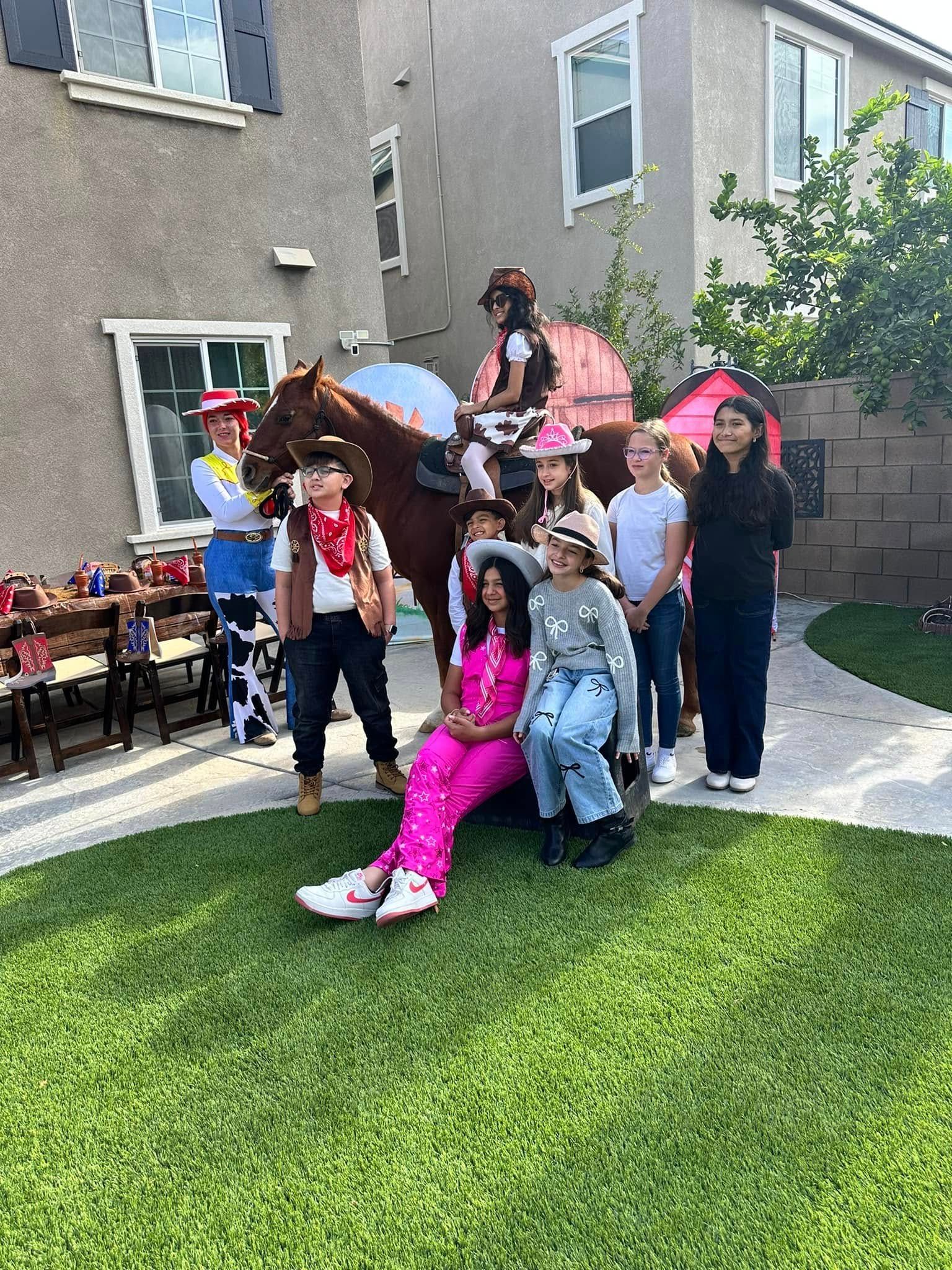 A group of children dressed as cowboys and cowgirls are posing for a picture with a horse.