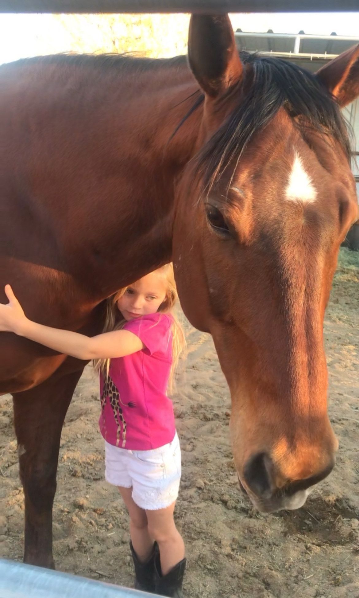 A little girl is riding a pony in a dirt field.