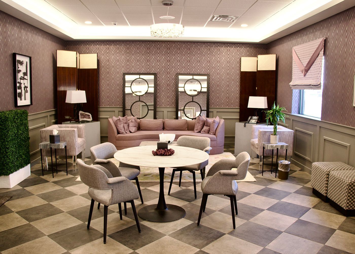 A living room with a round table and chairs and a checkered floor.