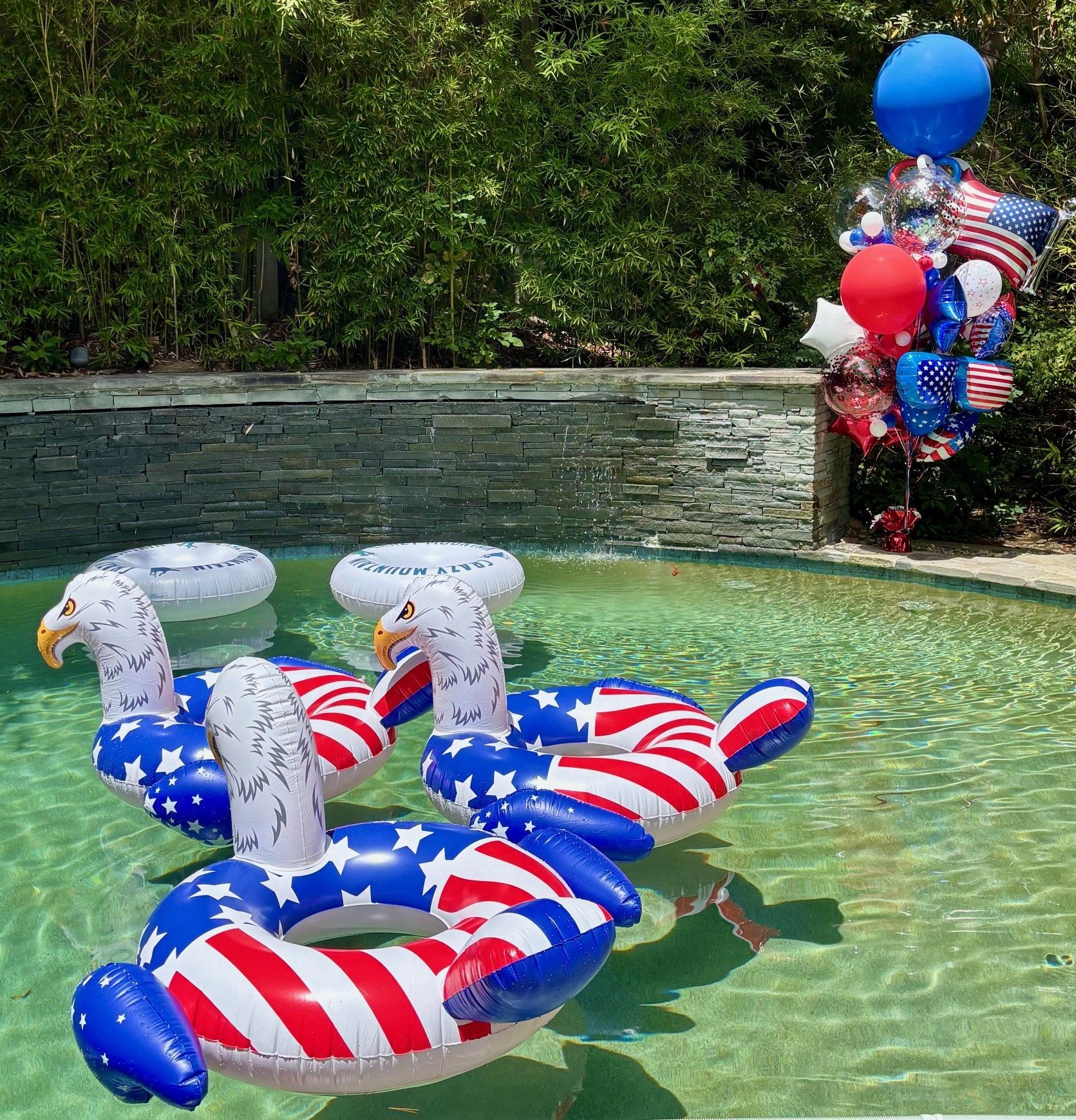 Oversized red, white and blue organic balloon bouquet styled poolside for a Fourth of July celebration