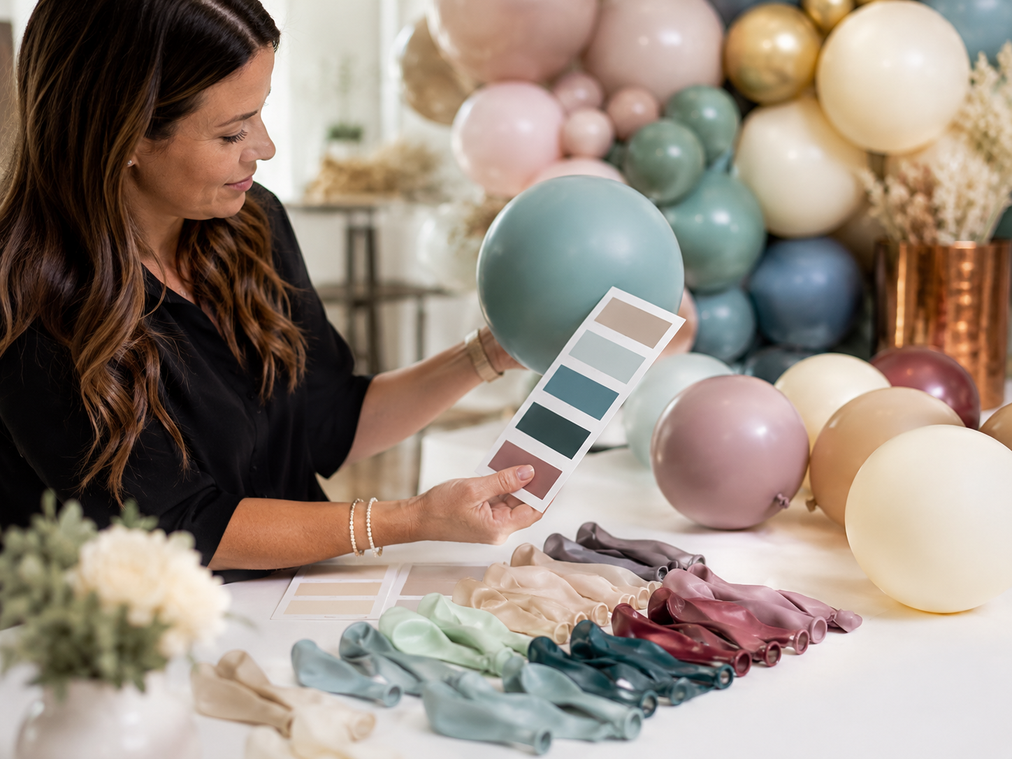 Balloon designer color-matching premium balloons to a client palette at a Los Angeles studio