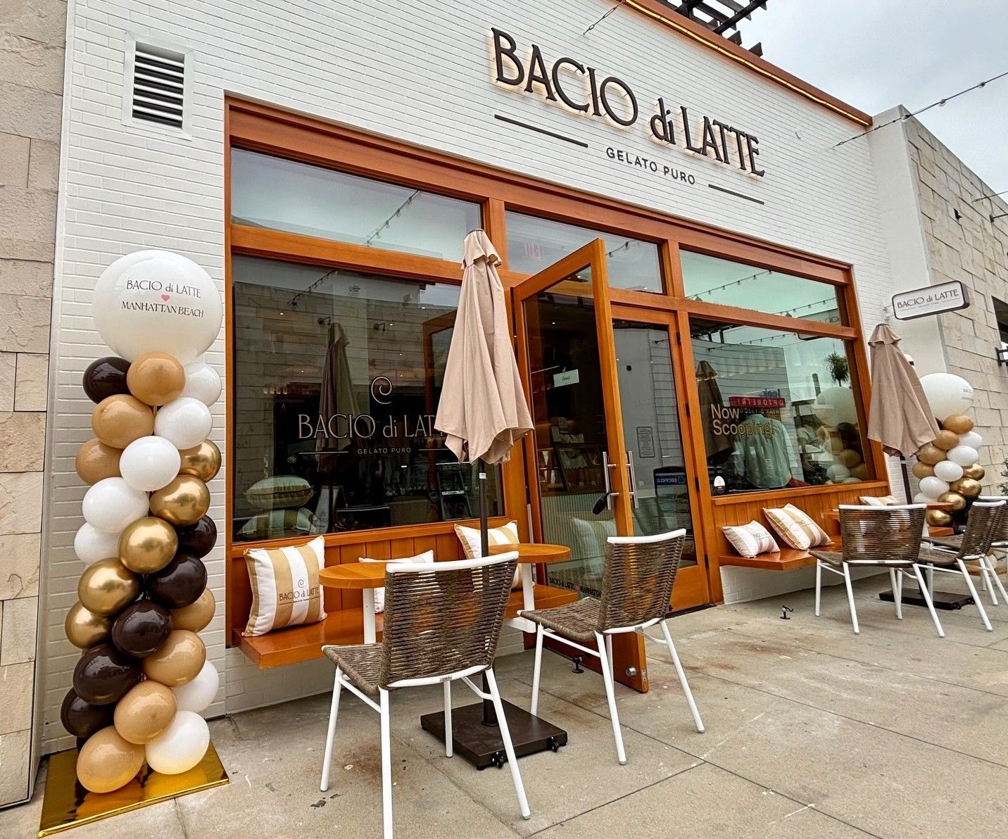 Two matching branded balloon columns framing the Bacio di Latte storefront entrance in Manhattan Beach