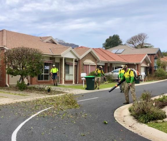 Workers Clearing Debris on A Suburban Street with Houses and A Utility Pole Visible — Ground Control Property Maintenance In North Boambee Valley, NSW