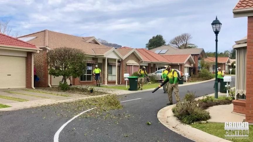 Workers in Safety Vests Using Leaf Blowers to Clear Debris — Ground Control Property Maintenance In North Boambee Valley, NSW