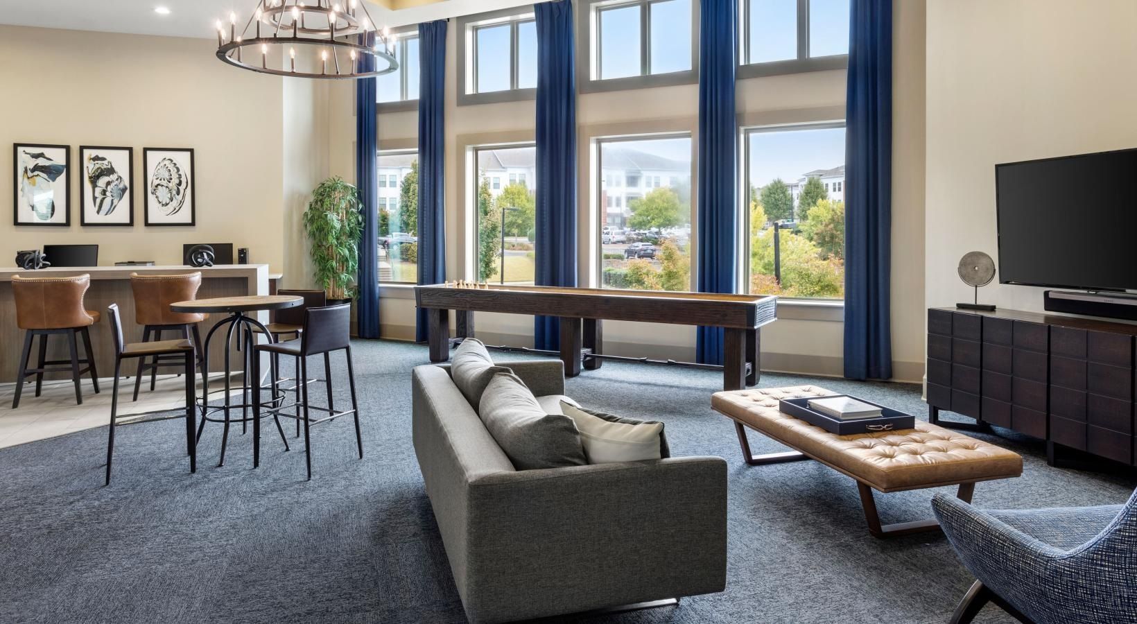 A living room with a couch , table , chairs and a pool table.