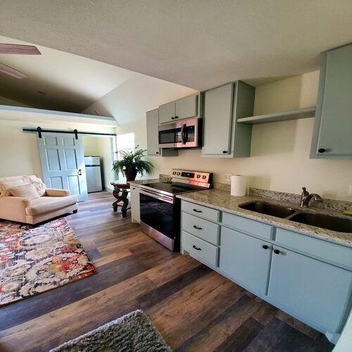 Kitchen and living room remodel with pale blue cabinetry and hardwood flooring