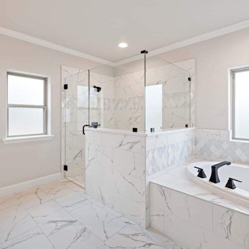 Master bathroom remodel with marble tile, frameless glass shower and freestanding soaking tub