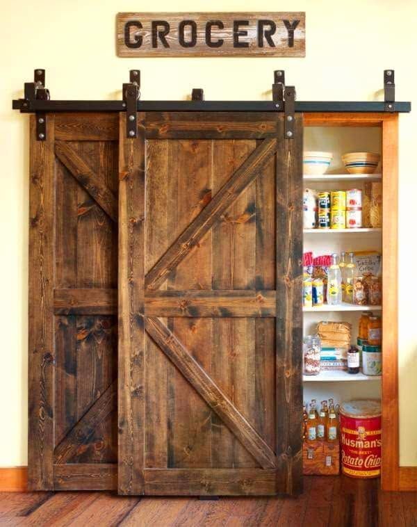 Rustic sliding barn doors open to pantry shelves; a wooden