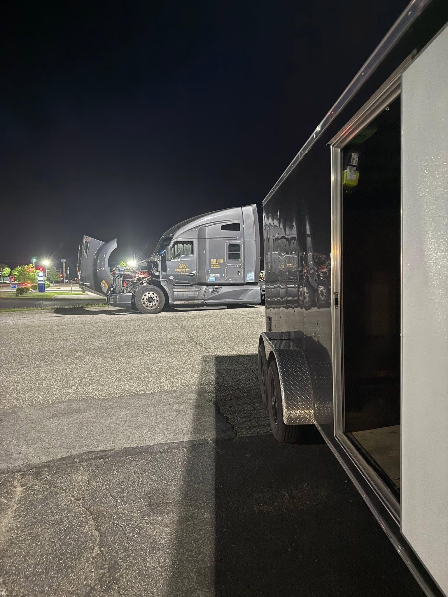 Nighttime RV parking lot with several trailers and a black trailer in the foreground. | 814 Truck & Equipment Services LLC