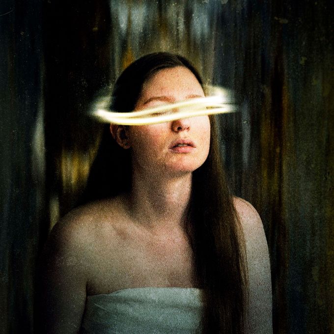 A woman with long hair and a ring around her eyes.