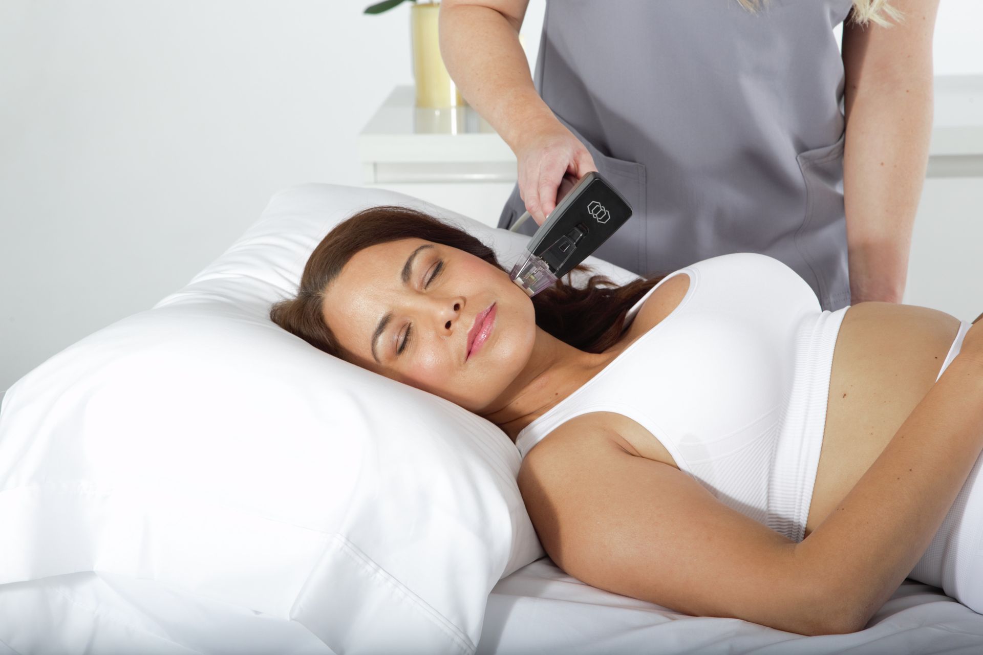 A person receives a skin treatment on their neck, in a medical setting.