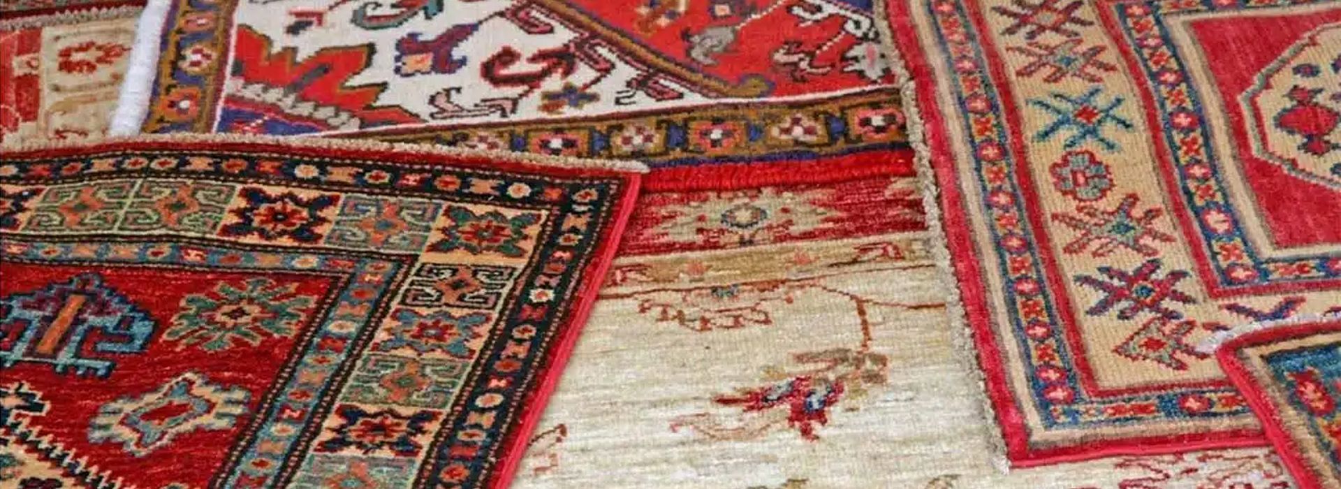 Hand-knotted Oriental rug with red and ivory border, cleaned by hand at Aegis Fine Rug Cleaning in A