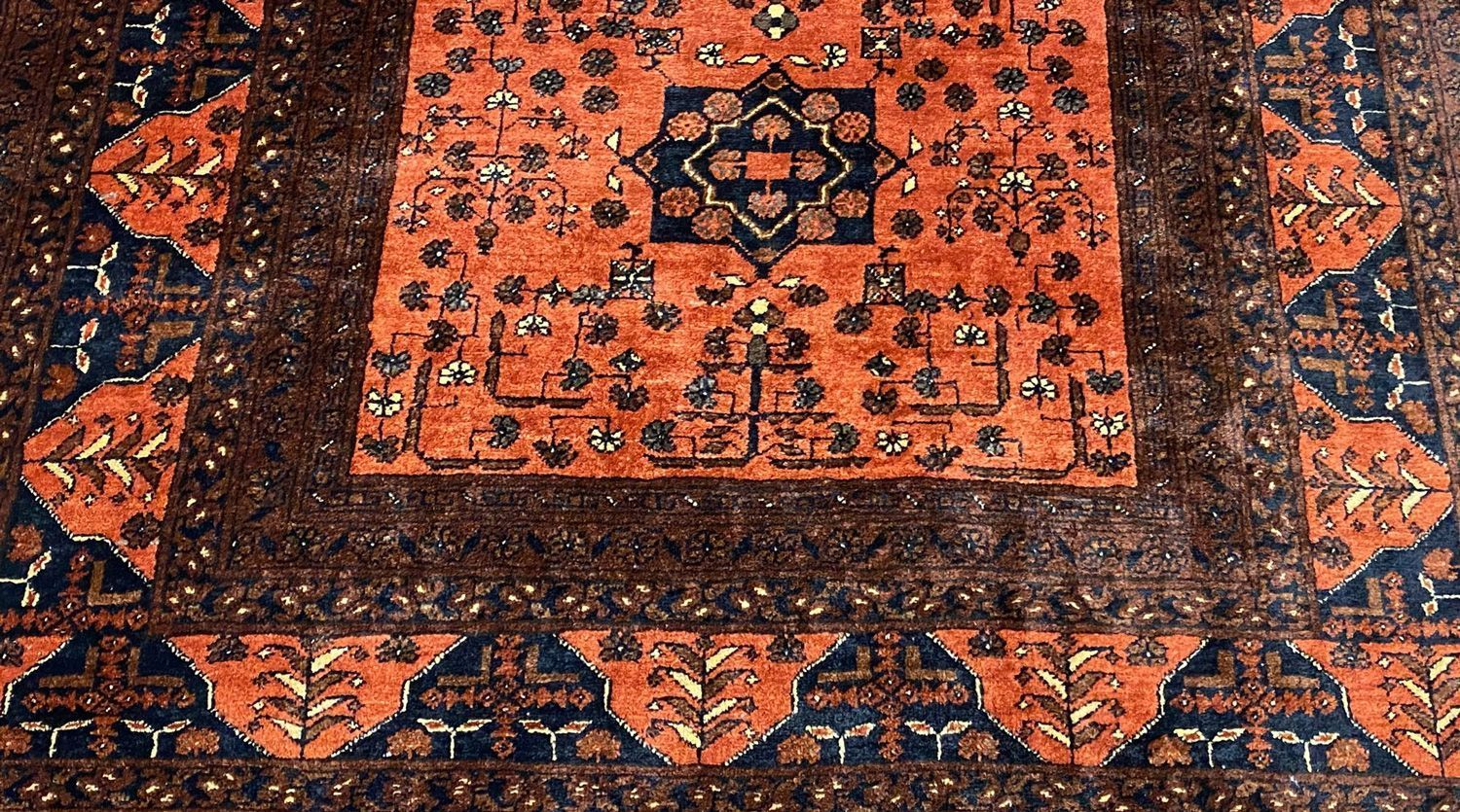 Hand-knotted Persian rug with rust and navy medallion, hand-washed by Aegis Fine Rug Cleaning in Austin