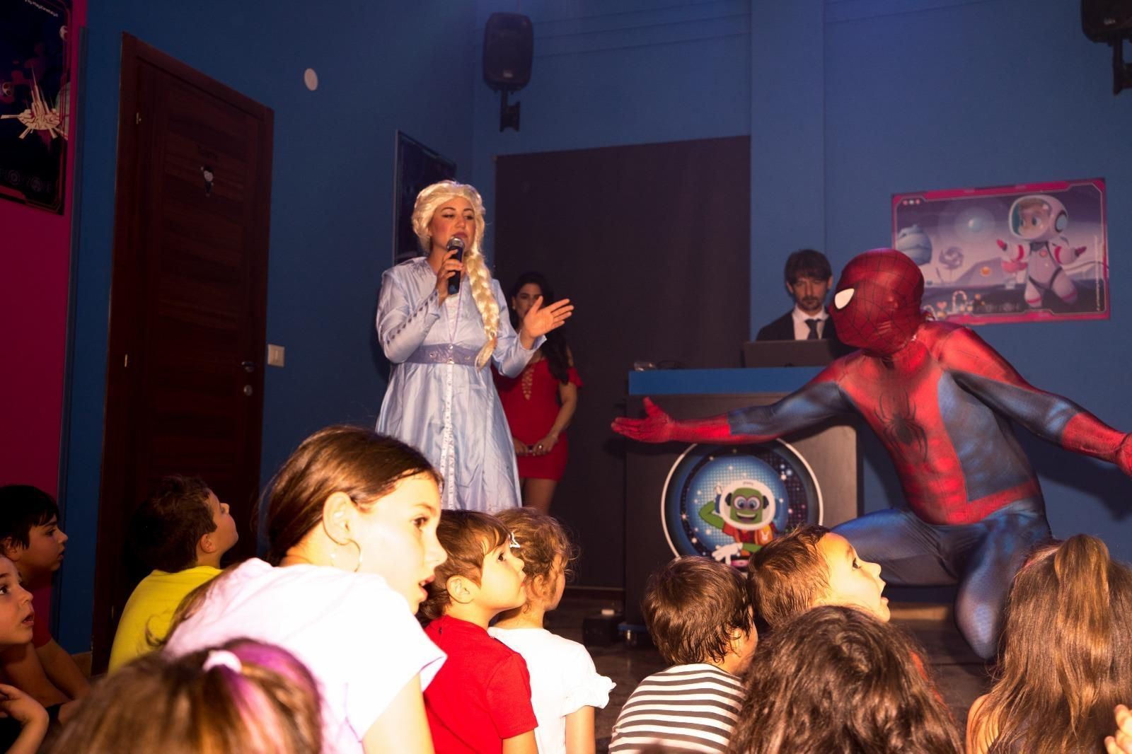 Un gruppo di bambini guarda l'esibizione di Spiderman ed Elsa