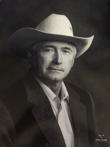 A black and white photo of a man wearing a cowboy hat and suit.