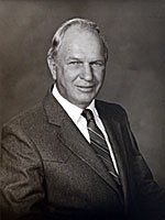 A black and white photo of a man in a suit and tie.