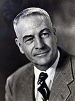 A black and white photo of a man in a suit and tie.