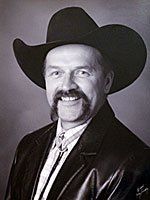 A man with a mustache is wearing a cowboy hat and a leather jacket.