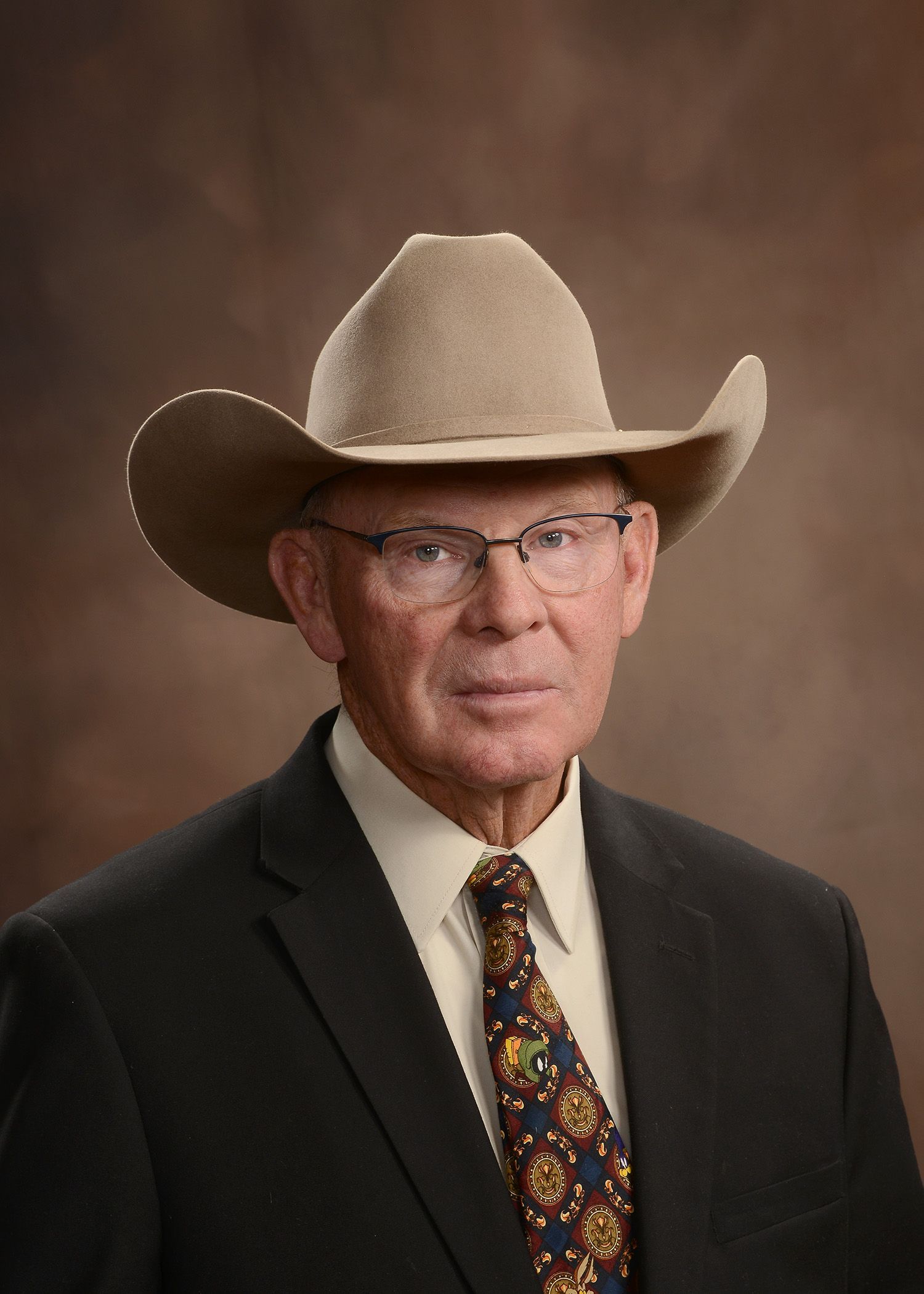 A man in a suit and tie is wearing a cowboy hat