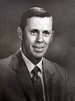 A black and white photo of a man in a suit and tie.