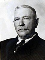 A black and white photo of a man in a suit and tie.