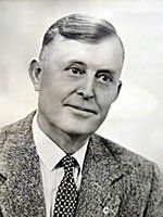 A black and white photo of a man in a suit and tie.