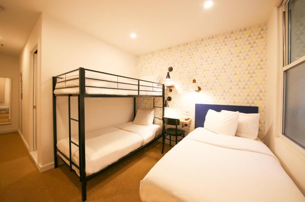 A hotel room with three beds and a bunk bed