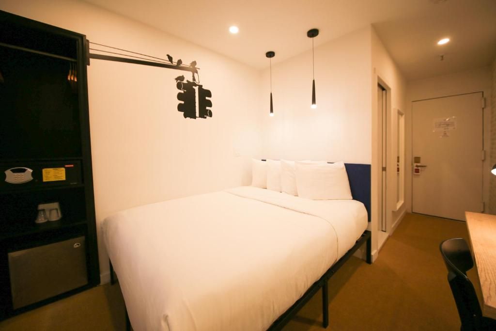 A hotel room with a large bed and a desk