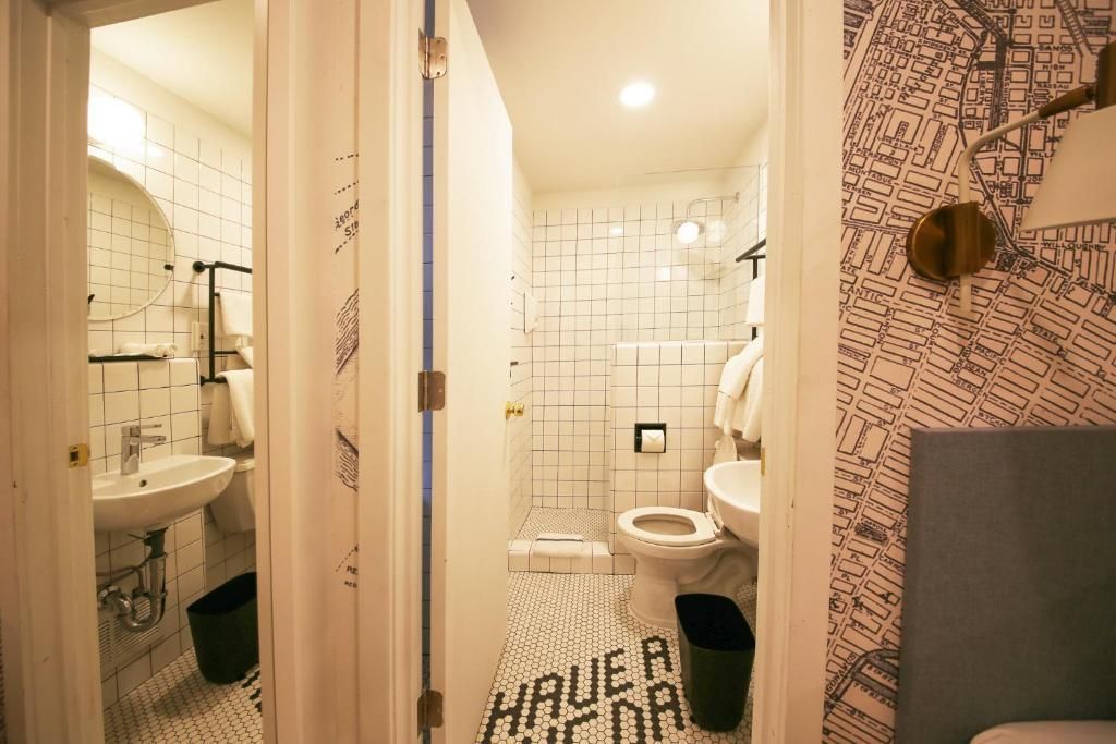 A bathroom with a toilet , sink , and mirror.
