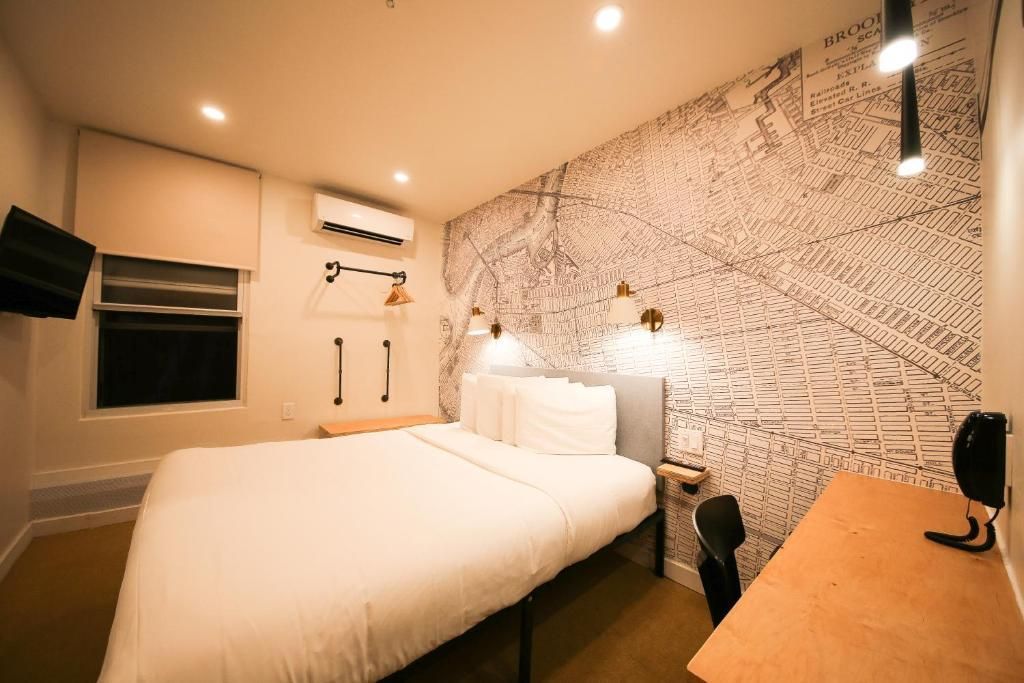 A hotel room with a bed , desk and television.