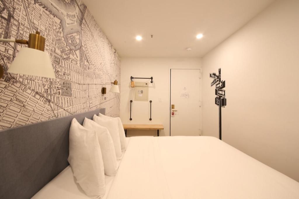 A hotel room with a large bed and a map on the wall.