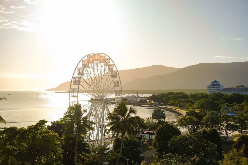 Ferris Wheel Near Water at Sunset, With Palm Trees and Mountains in the Background — My Habitat Products in Cairns, QLD