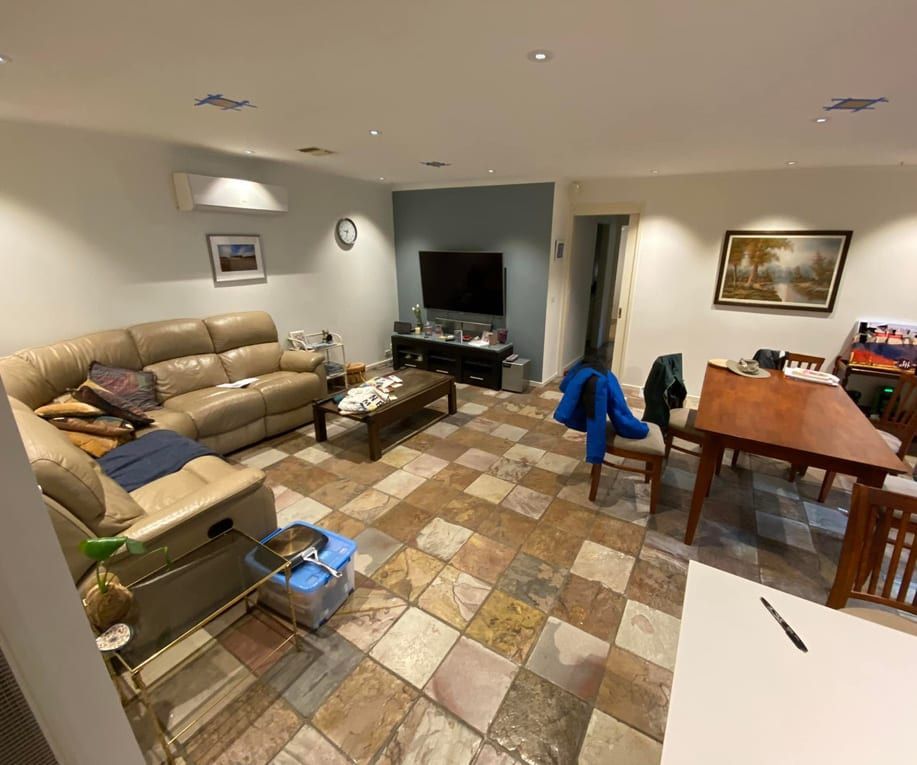 A living room with a couch , table , chairs and a television.