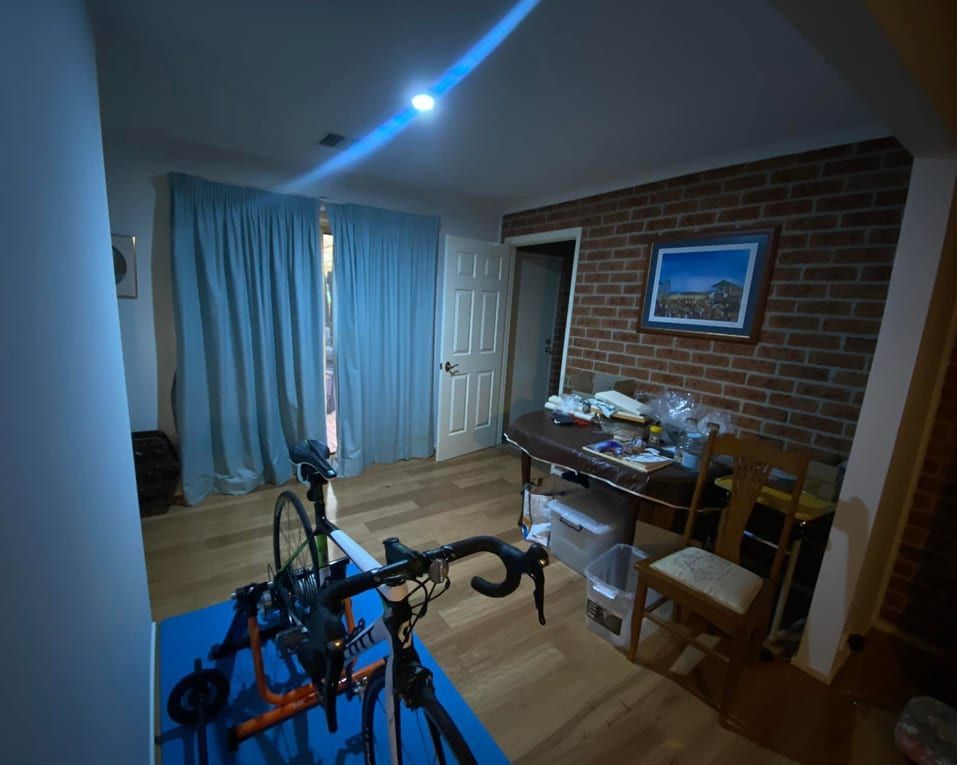 A room with a brick wall and a bicycle on the floor