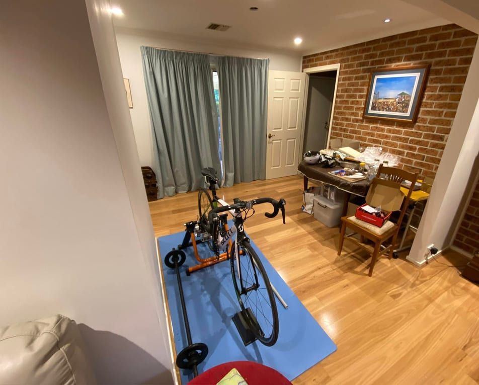 A bicycle is sitting on a blue mat in a room.