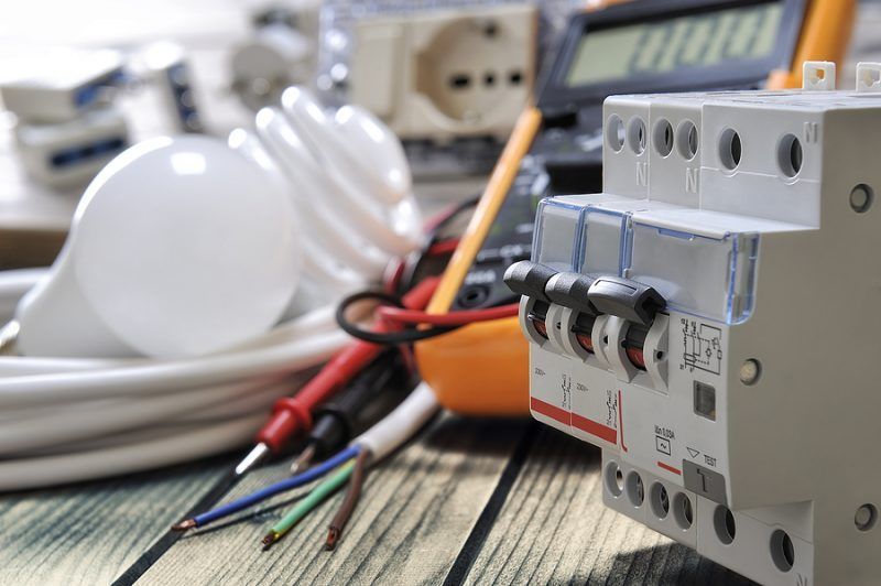 A bunch of electrical equipment is sitting on a wooden table.