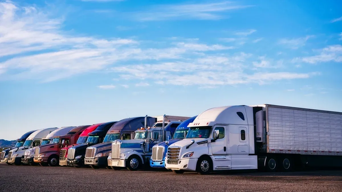 Freight vehicles lined up in a parking lot. These vehicles can cause great damage to regular passenger cars.