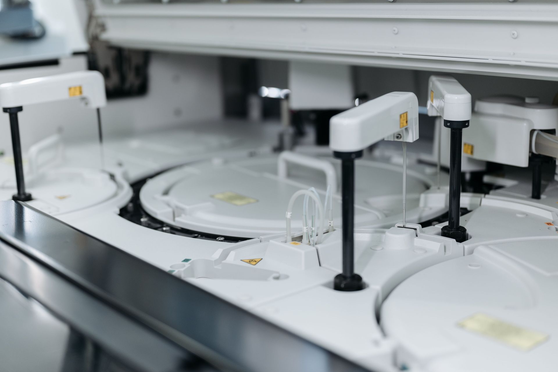 Máquina de laboratorio automatizada con bandejas blancas y brazos robóticos para la manipulación de muestras.