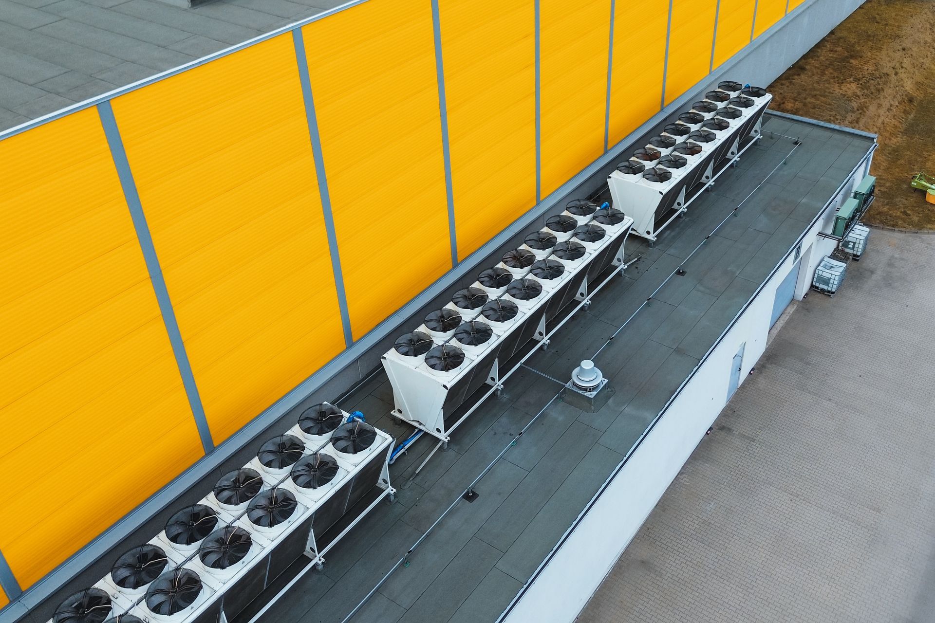 Yellow building roof with industrial HVAC units.