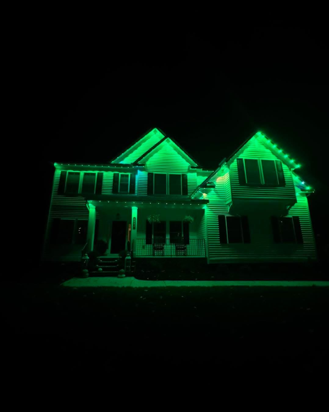 House illuminated with bright green lights at night