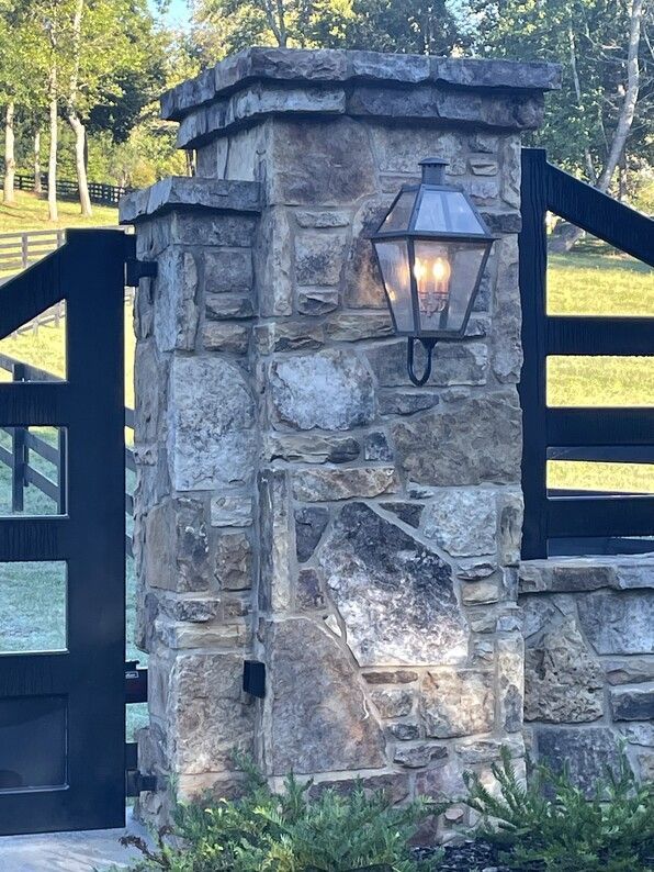 Stone pillar with black gate and lantern.