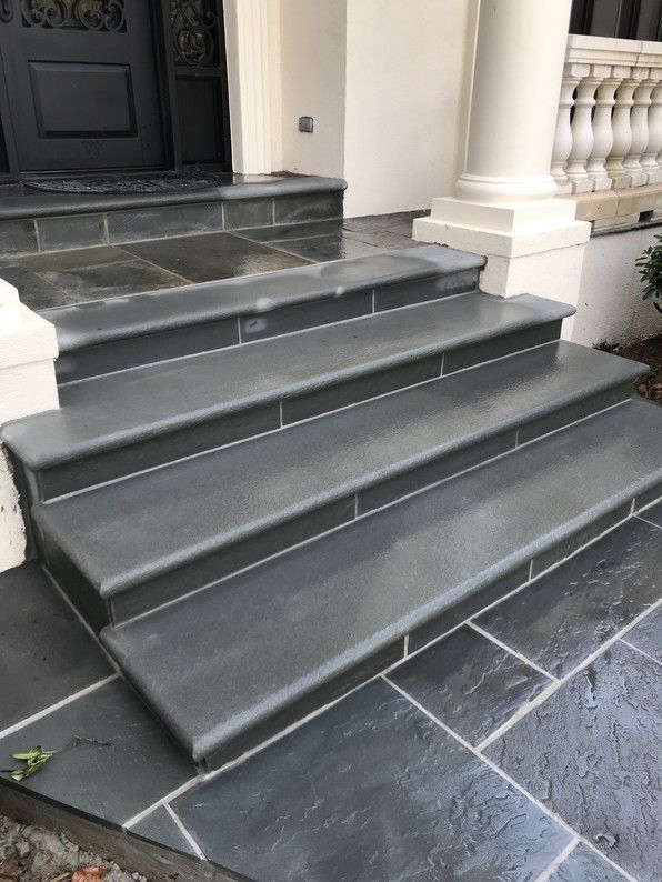 Stone steps leading to a front door with a matching stone walkway.